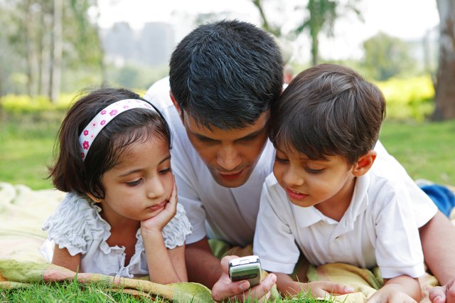 Father showing his mobile to his children