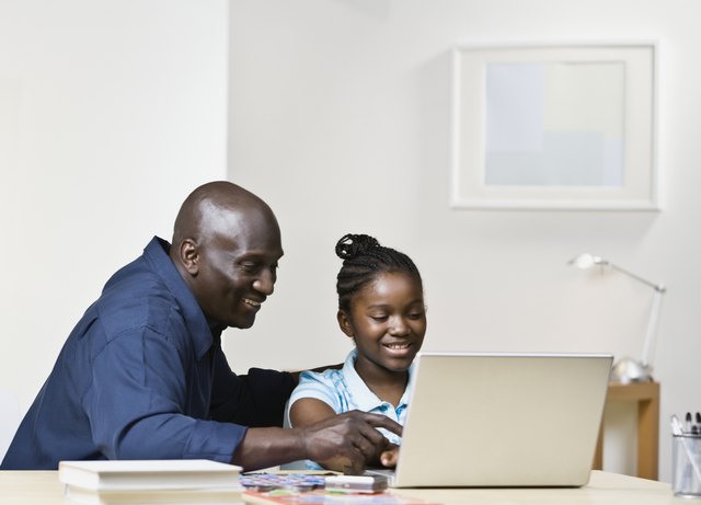 African father and daughter looking at laptop