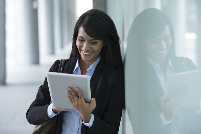 Young Indian businesswoman standing outside using Tablet PC
