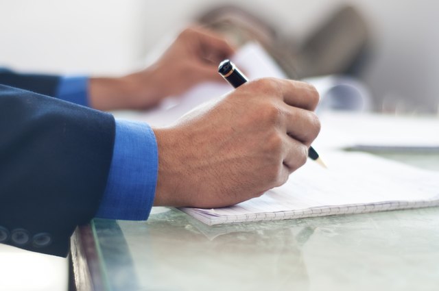 Businessman writing on a notepad