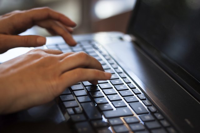Detail of hands working on computer keyboard