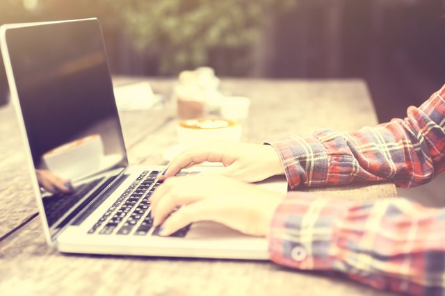 woman typing on a laptop at sunrise