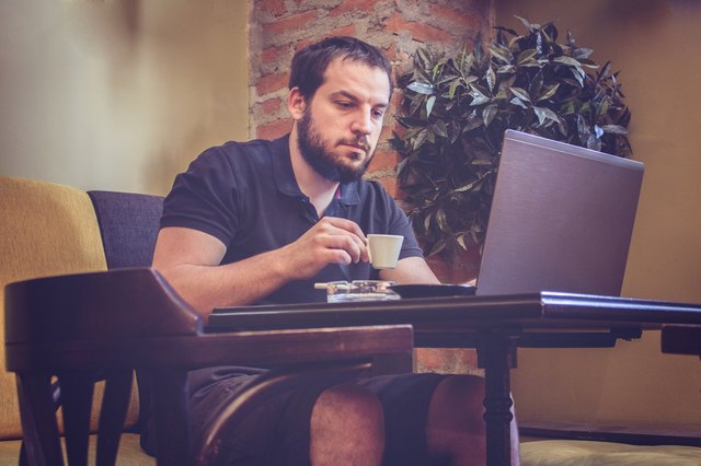 Businessman Using Laptop at Office Coffee Bar