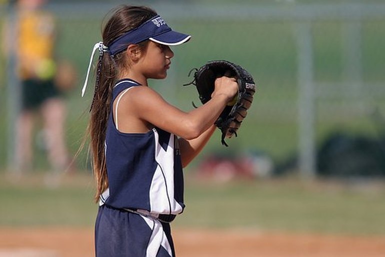 A young girl playing softball